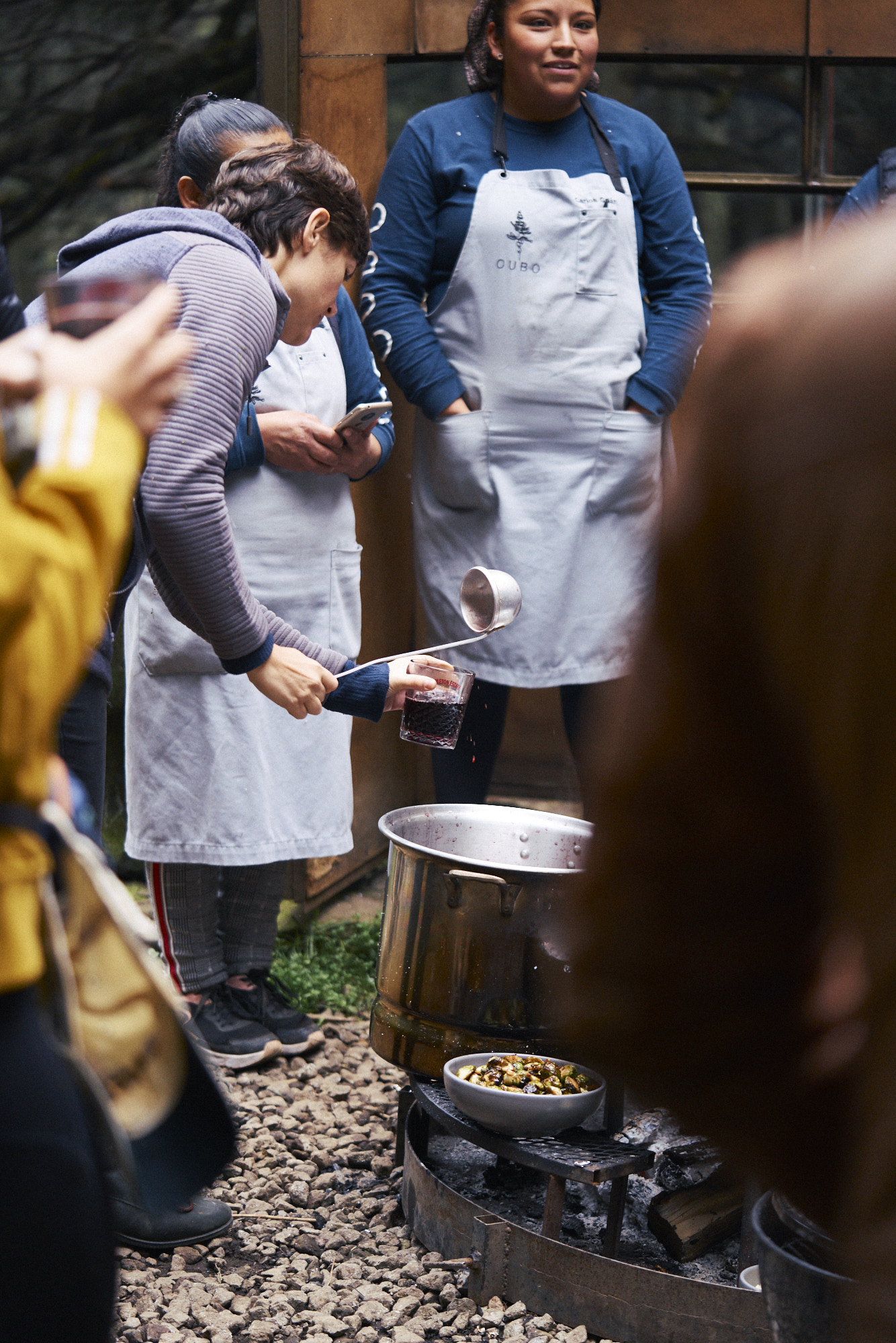 Cocineras preparando alimentos al fuego al aire libre